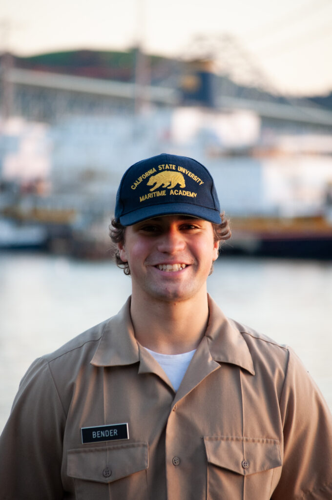 Man in a Maritime uniform smiling in front of a port. 